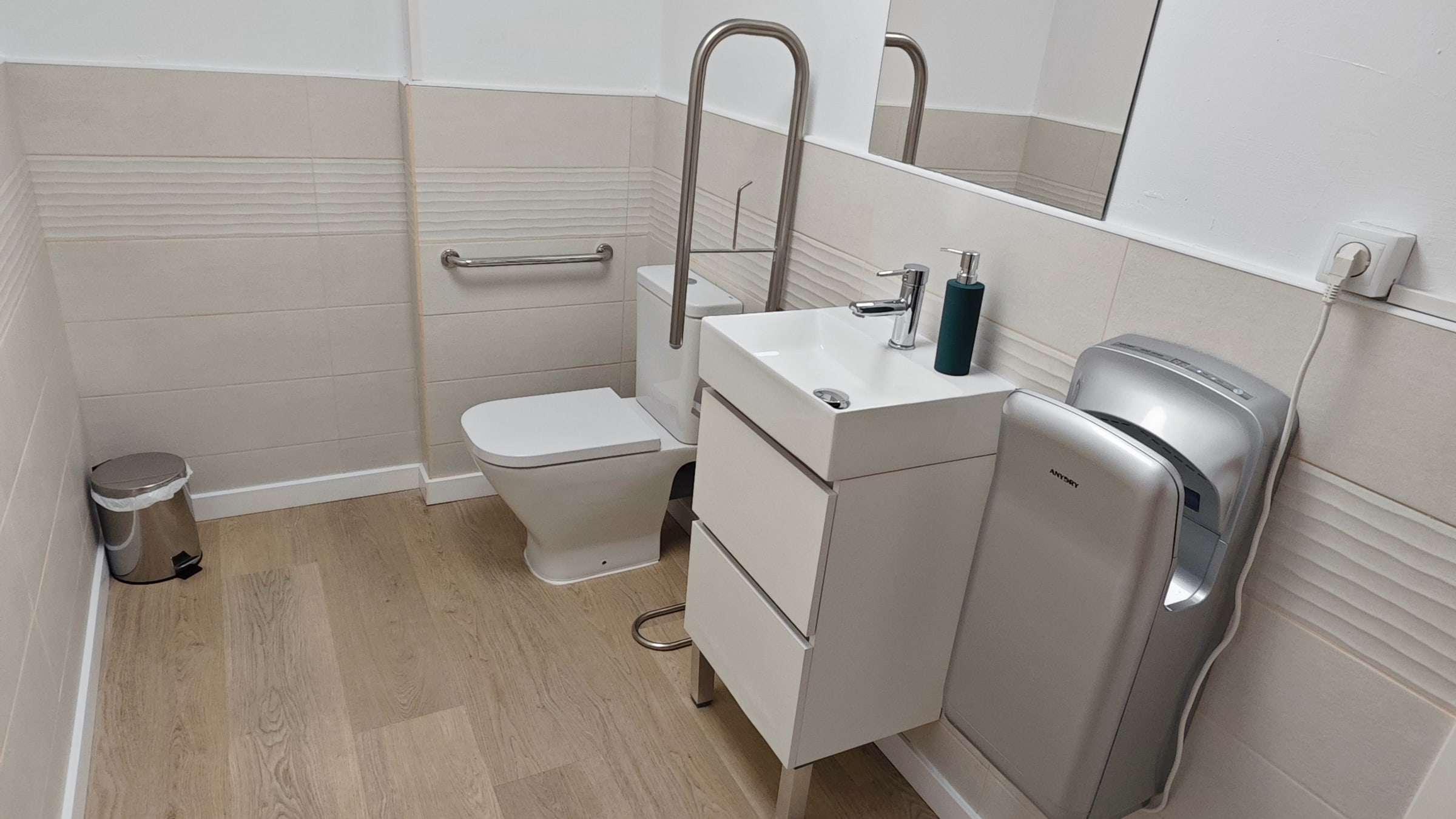 Lavabo adaptado con barras de apoyo, lavamanos y secamanos eléctrico