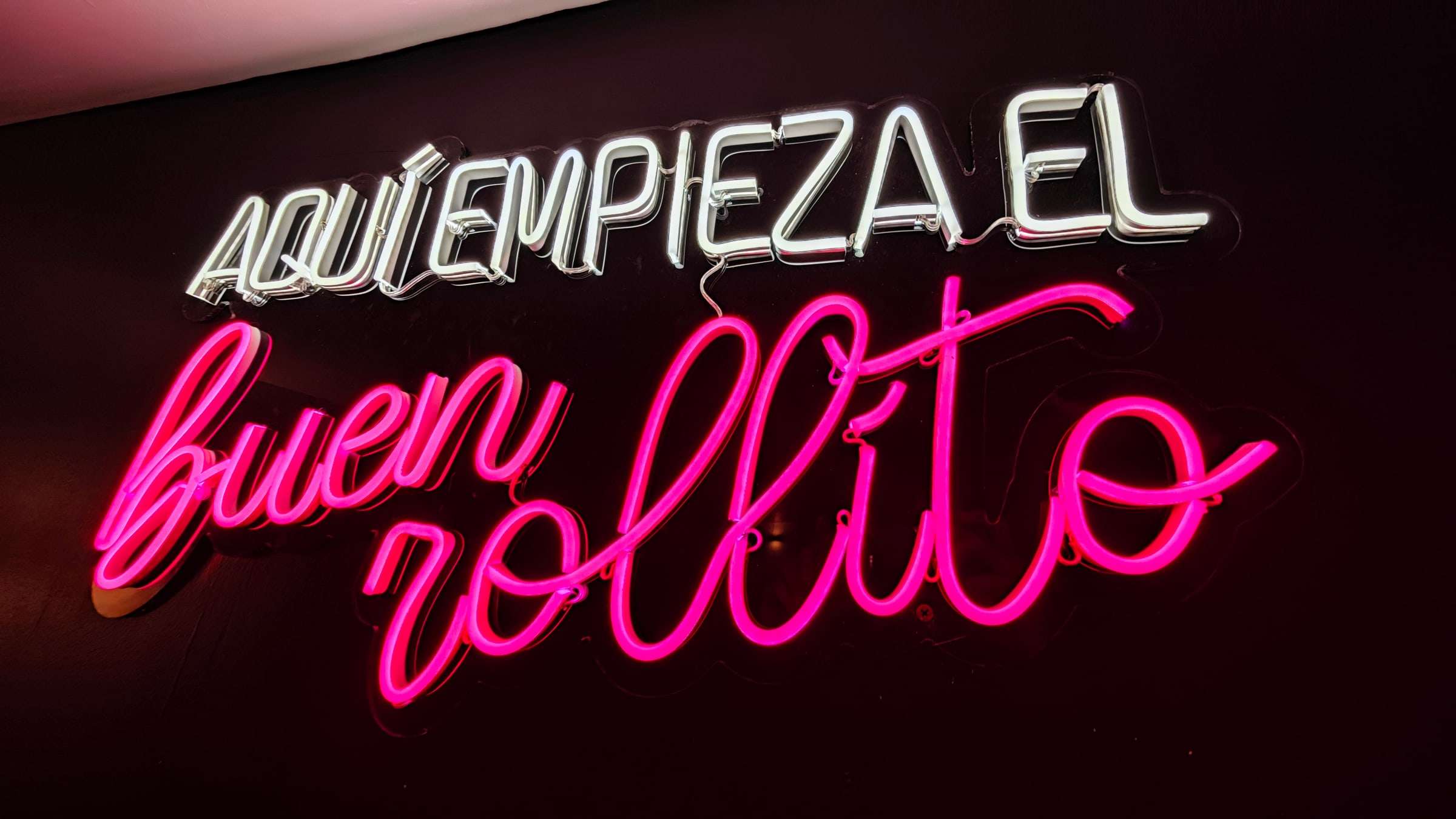 Letrero de neón con el texto «Aquí empieza el buen rollito»