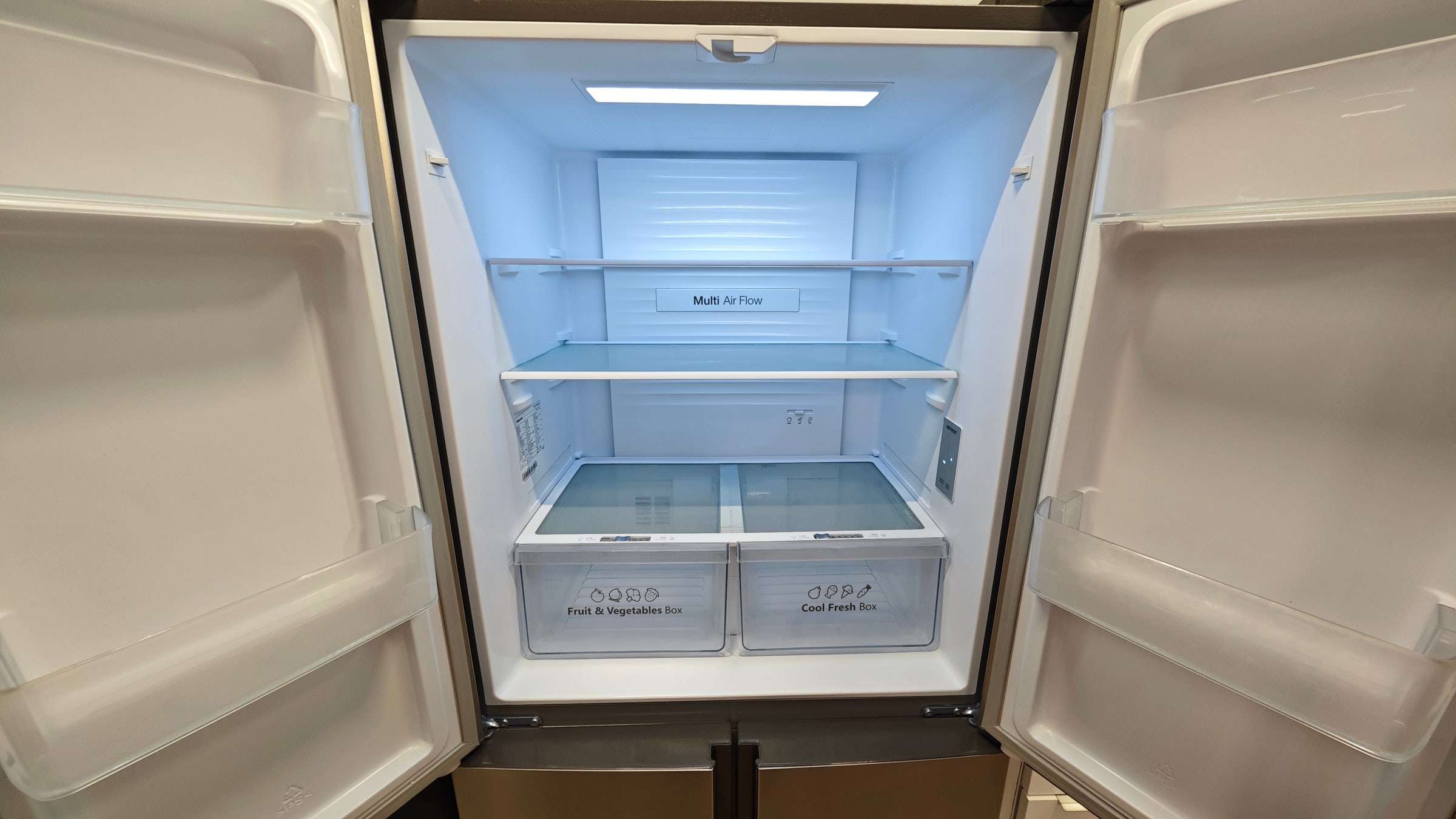 Nevera XL de doble puerta abierta y vacía, preparada para guardar la comida del evento