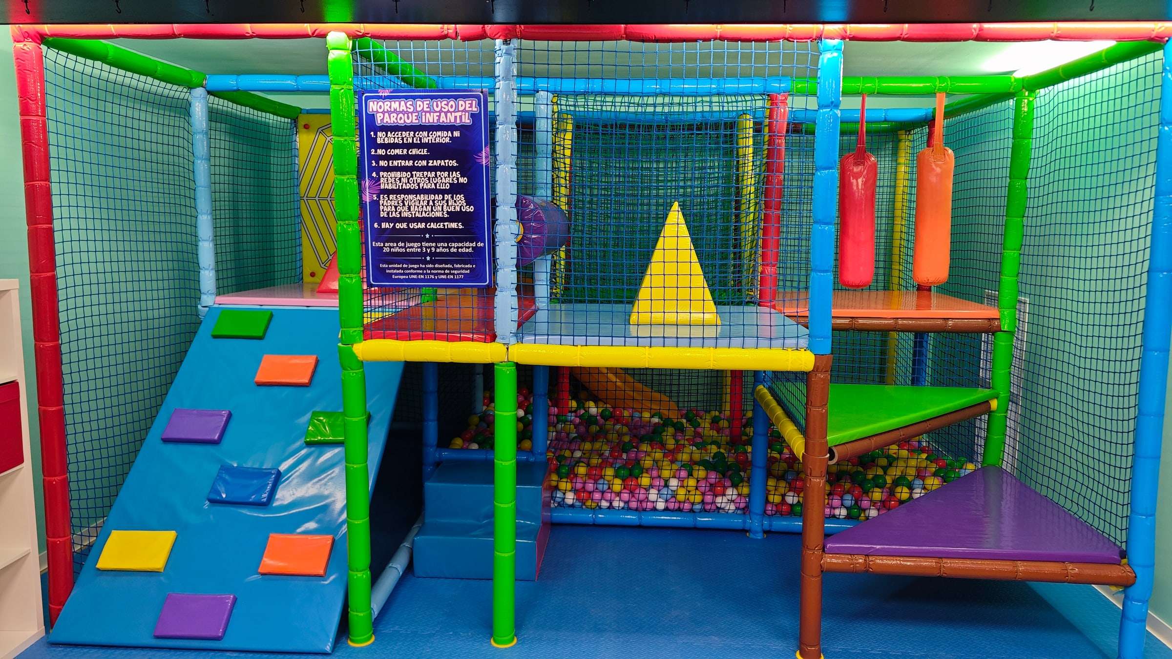 Parque infantil de bolas con estructura de colores, rampa y redes de seguridad
