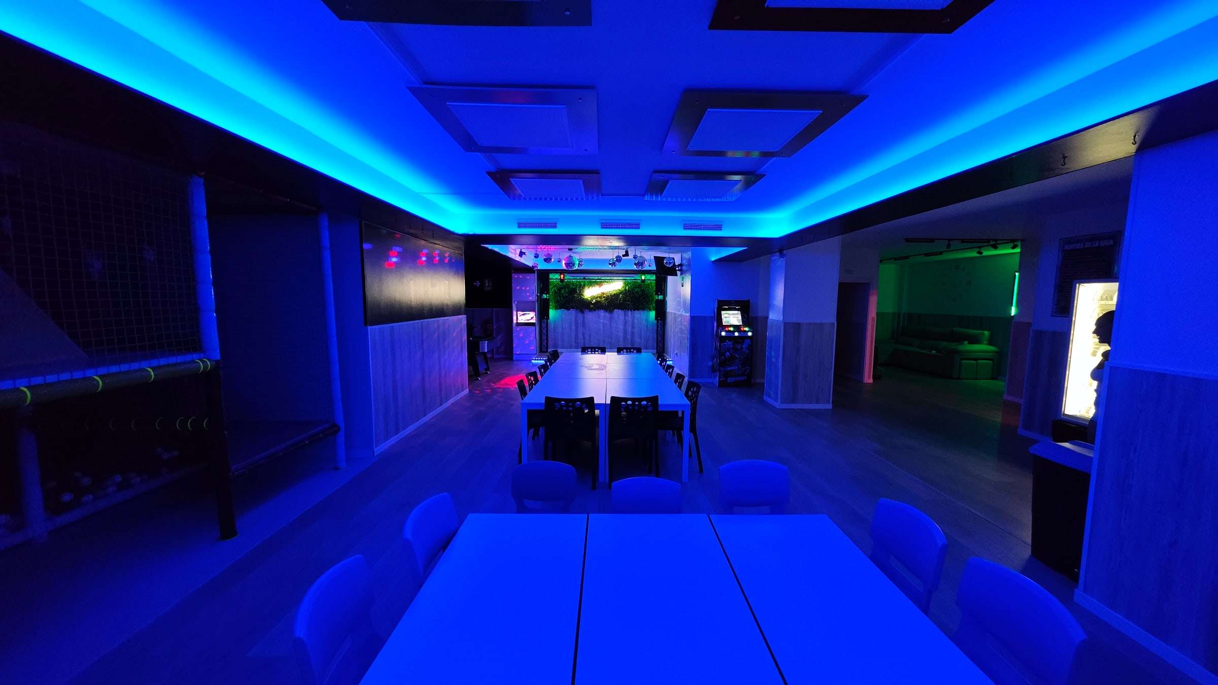 La sala completa con iluminación LED azul y las mesas montadas para una celebración